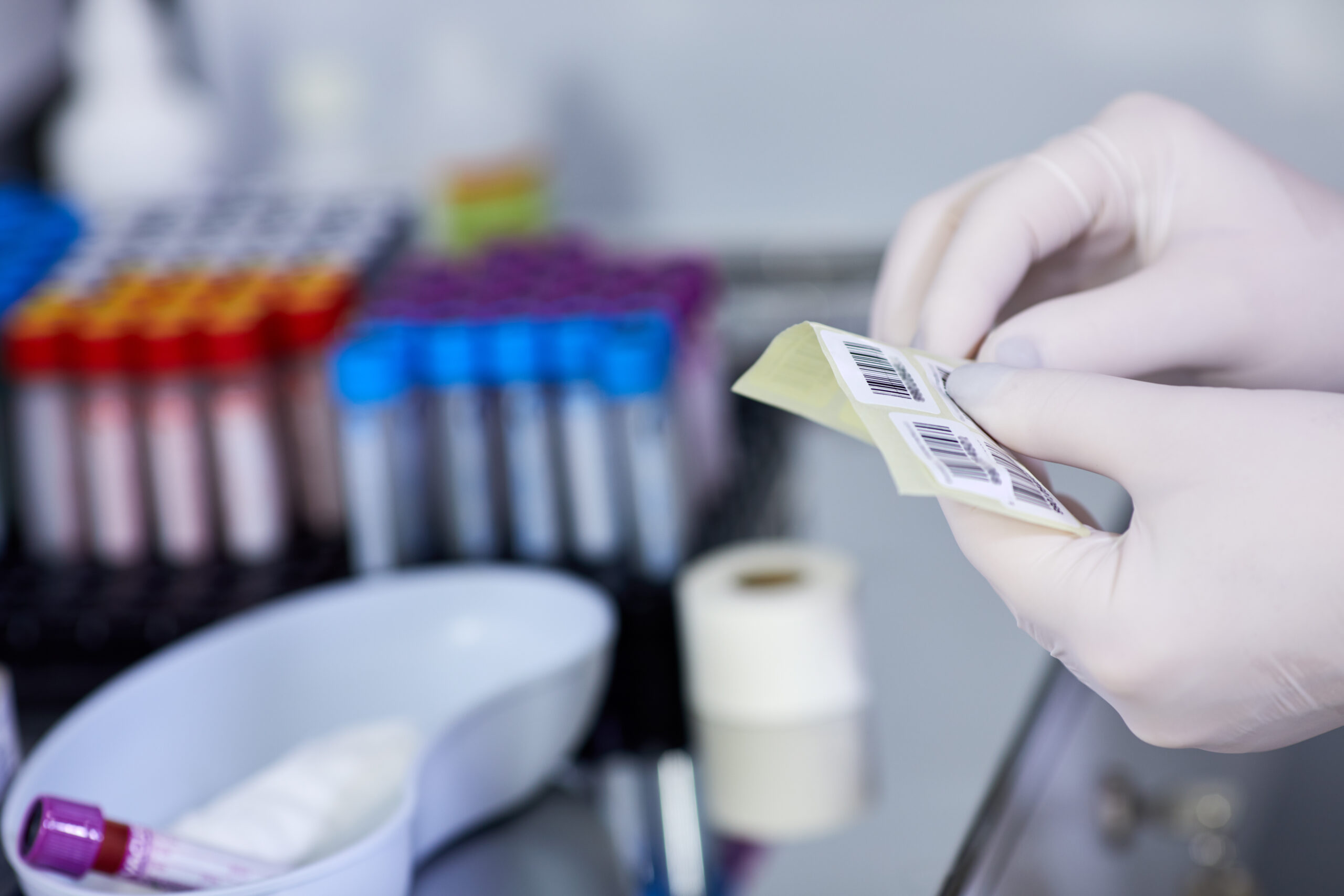 Selective focus scientist hand holding red blood bag in storage